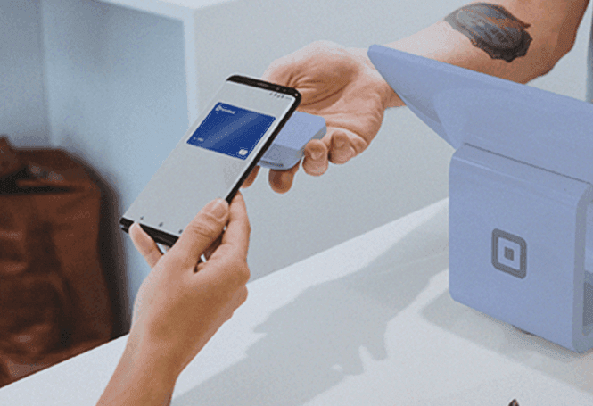 Pagamento por aproximação com smartphone exibindo cartão digital Porto Bank.