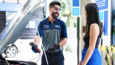 Mecânico inspeciona o sistema elétrico de um carro durante uma revisão